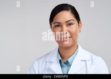 The face of scientific research. Cropped portrait of an attractive young female scientist posing in studio against a grey background. Stock Photo