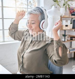 Dance, headphones and music by senior business woman in office, happy and excited about small business. Earphones, dancing and elderly female Stock Photo