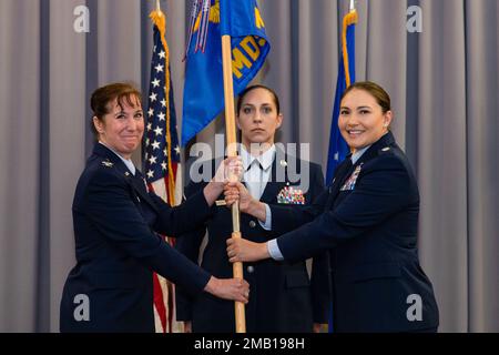 Lt. Col. Kristen Carter, right, outgoing 436th Medical Support Squadron commander, relinquishes command of the 436th MDSS after handing the guidon to Col. Tracy Allen, left, 436th Medical Group commander, at The Landings on Dover Air Force Base, Delaware, June 9, 2022. Constituted in 1992, the 436th MDSS held an inactivation ceremony and was the first of four ceremonies conducted within the 436th MDG. Guidon bearer for the ceremony was Master Sgt. Amy Schwiesow, center, 436th MDSS superintendent. Stock Photo