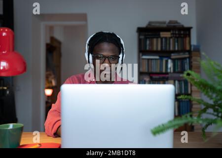 Unhappy tired young African student guy looking at laptop feeling overwhelmed with online classes Stock Photo