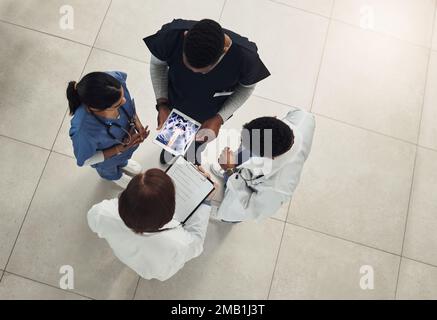 Thank you for coming so quickly. a group of doctors and nurses using a digital tablet during their meeting. Stock Photo