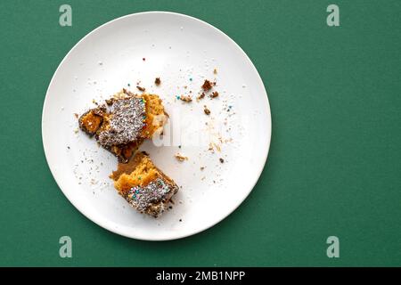 Sweet dessert food leftover on a white ceramic plate with green tablecloth Stock Photo
