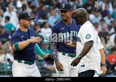 Seattle Mariners former second baseman Bret Boone, left, and former  outfielder Mike Cameron, right, stand in the dugout before throwing out  ceremonial first pitches before a baseball game between the Mariners and