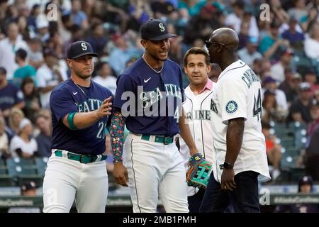 Seattle Mariners former second baseman Bret Boone, left, and former  outfielder Mike Cameron, right, stand in the dugout before throwing out  ceremonial first pitches before a baseball game between the Mariners and