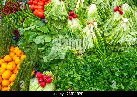 Fresh green leaves of salads, radish, tomatoes, vegetables on a street market in Turkey Stock Photo