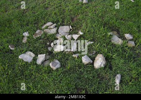 Portrait of stone fragments made of cement on a green grassy field. Stock Photo