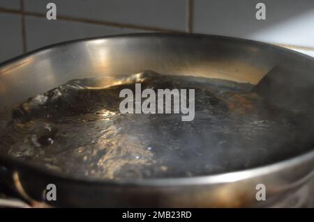 Portrait of boiling water in a boiling pot. Stock Photo