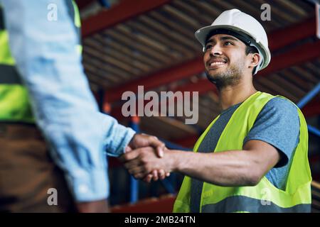 Trust, respect and reliability, everything great partnerships are built on. two builders shaking hands at a construction site. Stock Photo