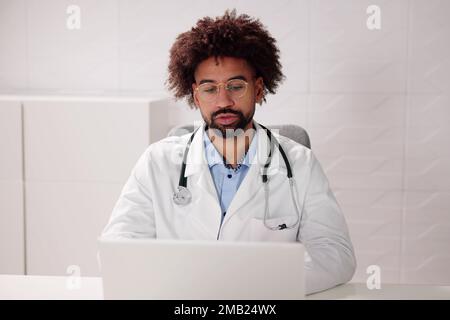 Doctor Having Video Conference On Laptop With Colleagues Stock Photo