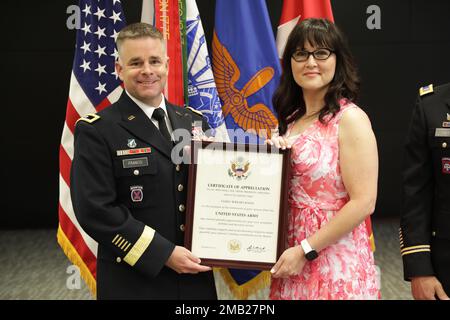 Maj. Gen. David J. Francis, U.S. Army Aviation Center of Excellence and Fort Rucker commander, presents Tasha Knox with a certificate of appreciation for her continued dedication and support to her husband, Chief Warrant Officer 5 Bernd Knox, as he completes retires from the Army after 28 years during his retirement ceremony at Fort Rucker, Alabama, June 10, 2022. Stock Photo