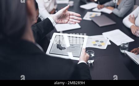 I have the figures in front of me. a mature businesswoman using a digital tablet during a business meeting. Stock Photo
