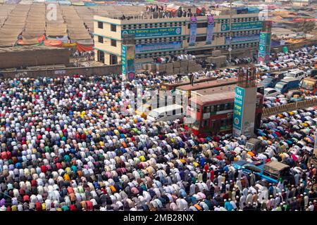 Dhaka, Bangladesh. 20th Jan, 2023. Muslim devotees pray in the middle of a busy road junction, causing traffic to come to a standstill, in Tongi, Dhaka, Bangladesh during Bishwa Ijtema, one of the major Islamic religious gatherings observed annually. Dedicated prayer grounds are not enough to handle this huge number of people, so large numbers of people come to Tongi, the main street of Dhaka. All the ground transportation and pedestrian crossings are suspended during that time. The Bishwa Ijtema (Global Congregation) is an annual gathering of Muslims in Tongi, by the banks of the River Turag, Stock Photo