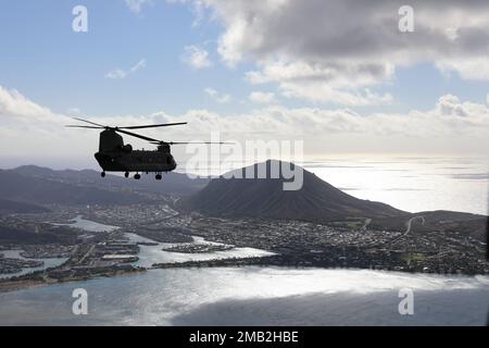 U.S. Army CH-47 Chinook helicopter flies over O'ahu while transporting Detachment 1, Golf Company, 1st Battalion, 189th Aviation Regiment and Detachment 1, Golf Company, 3rd Battalion, 126th Aviation Regiment Soldiers to a training location at Hilo, Hawaii, June 10, 2022. The Hawaii Army National Guard Soldiers planned to participate in a multi-day training exercise involving flight operations, weather forecasting, maintenance, fuelers, flight medics, flight crew chief, and pilots. Stock Photo