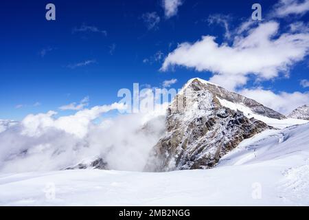 Look to Aletsch Glacier from the Jungfraujoch. Blue sky with clouds in between mountain peak. Bernese Alps, Switzerland, Europe Stock Photo