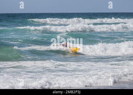 Padstow, Cornwall united kingdom September, 06 2012 uk life guard surfer on a yellow r n l i surf board Stock Photo