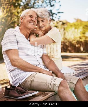 Senior couple, relax and smile by pool in love and summer vacation, bonding or quality time together in the outdoors. Happy elderly man and woman Stock Photo