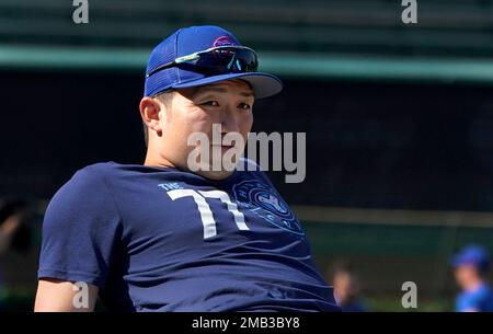 Chicago Cubs' Seiya Suzuki stretches and watches batting practice