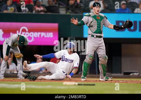 Houston Astros' Jeremy Pena, right, slides to score as Texas Rangers  catcher Jonah Heim, left, waits for the throw on a sacrifice fly by Yanier  Diaz during the fourth inning of a