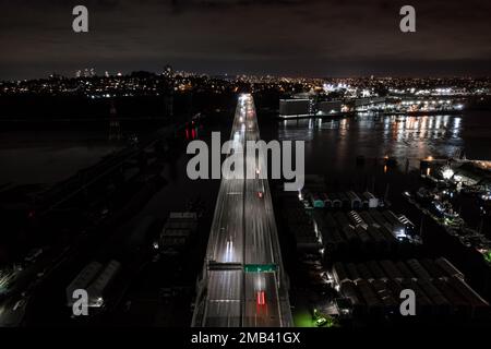 Night city street view, fast traffic, bridge over water, cars light streaks, transportation network, road. Stock Photo