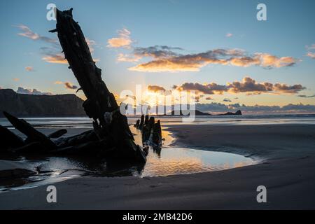 Wreck of the Helvetia, shipwreck on Rhossili beach at sunset, no people. Gower Peninsula, South Wales, the United Kingdom, UK GB. Stock Photo