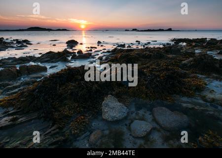 Rocks on the beach of Port Blanc in the evening light, Brittany, France, sunset Stock Photo