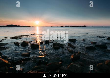 Rocks on the beach of Port Blanc in the evening light, Brittany, France sunset Stock Photo