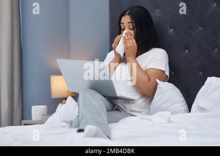 Flu season kicking in. a young woman feeling sick in bed at home. Stock Photo