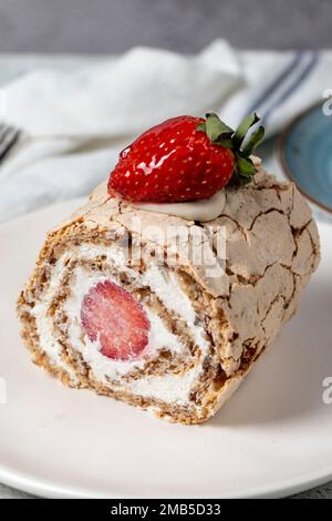 Strawberry Roll Cake. Cream and strawberry log cake with coffee on stone background. close up Stock Photo