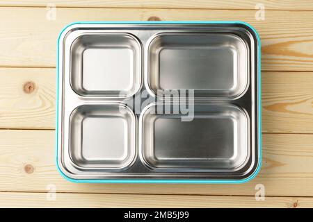 Metal lunch box with compartments on wooden background Stock Photo