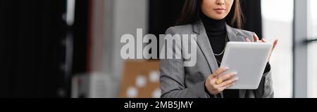 Cropped view of brunette designer using digital tablet in studio, banner,stock image Stock Photo