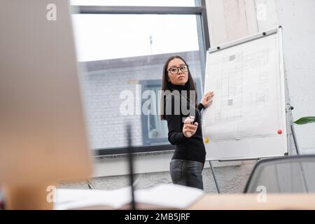 Asian designer working with computer and blueprint on flip chart in office,stock image Stock Photo