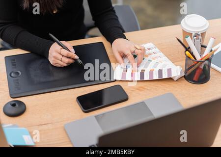 Cropped view of interior designer using color samples and graphic tablet in studio,stock image Stock Photo