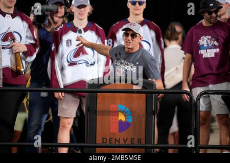 Colorado Avalanche center Joe Sakic, right, hugs retired goalie Patrick Roy  as team owner E. Stanley Kroenke, third from right, and Pierre Lacroix,  team president, look on after Roy's number 33 was