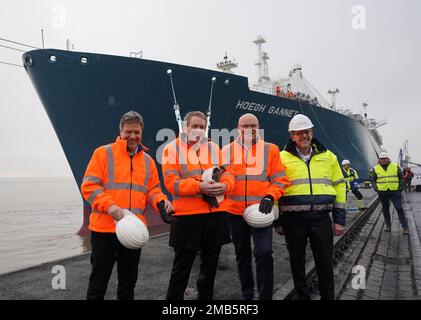 20 January 2023, Schleswig-Holstein, Brunsbüttel: Robert Habeck (l-r, Bündnis 90/Die Grünen), Federal Minister for Economic Affairs and Climate Protection, Daniel Günther (CDU), Minister President of Schleswig-Holstein, Tobias Goldschmidt (Bündnis 90/Die Grünen), Schleswig-Holstein's Minister for Energy Transition, Climate Protection, Environment and Nature, and Frank Schnabel, Managing Director of Brunsbüttel Ports GmbH, stand in front of the floating LNG terminal after the ceremony in the Elbehafen. At the floating LNG terminal 'Höegh Gannet', liquid natural gas is processed for transport in Stock Photo