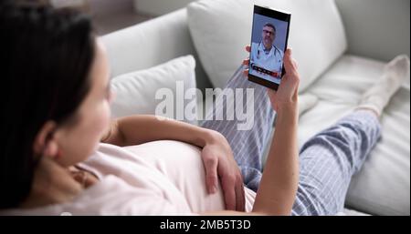 Pregnant Woman Using Online Video Call With Doctor On Mobile Phone Stock Photo