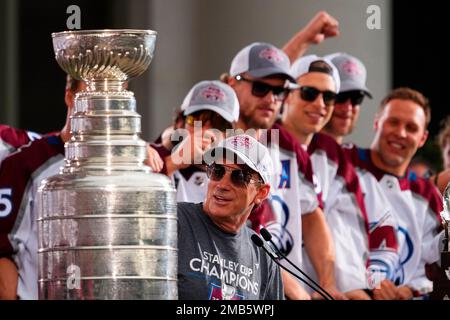 Colorado Avalanche center Joe Sakic, right, hugs retired goalie Patrick Roy  as team owner E. Stanley Kroenke, third from right, and Pierre Lacroix,  team president, look on after Roy's number 33 was