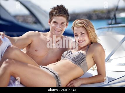 Taking their summer vacation. Loving young couple lying in the sunshine together. Stock Photo