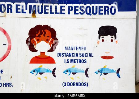 Detail of sign encouraging social distancing to prevent the spread of the covid-19 coronavirus in fishing docks, Caldera, Chile. Dorado is the fish species Seriola lalandi, common in the Pacific Ocean and an important catch for Chilean fishermen. Stock Photo