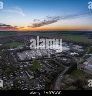 Aerial view of the expansive Tesco superstore in Bar Hill, Cambridge, bathed in the golden glow of a warm summer sunset Stock Photo