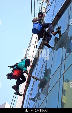 Workers glass cline a high-rise building on a construction site area in Dhaka Stock Photo