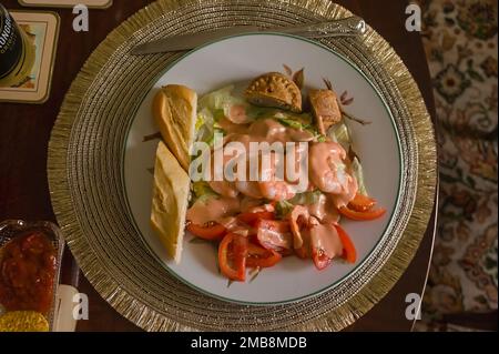 looking down at a tasty shrimp salad meal with pork pie on a table setting Stock Photo