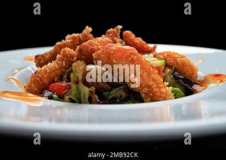 Vegetable salad with shrimp in batter and sauce, on a plate Stock Photo