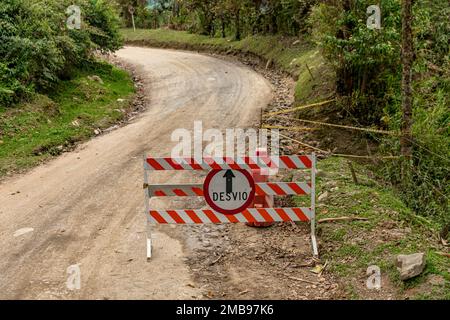 barrier with a no entry sign on a dirt road, detour - written in Spanish on the sign Stock Photo
