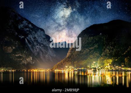 Night sky with the Milky Way and mountains over the iconic town of Hallstatt in Austria, Europe Stock Photo