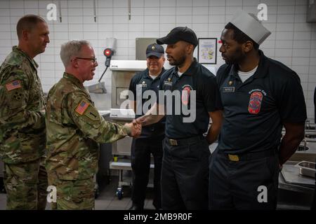 U.S. Army Maj. Gen. Greg Brady, Commanding General of the 10th Army Air and Missile Defense Command, and U.S. Army Command Sgt. Maj. Giancarlo Macri, the command sergeant major of the 10th AAMDC presents a commander’s coin for excellence to the Soldiers of Defender Café, on Rhine Ordnance Barracks on June 14, 2022. Stock Photo