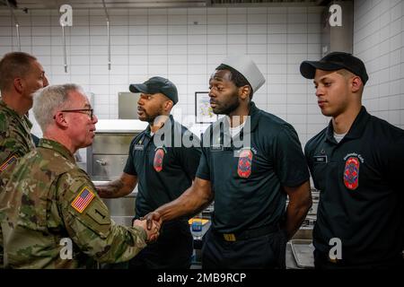 U.S. Army Maj. Gen. Greg Brady, Commanding General of the 10th Army Air and Missile Defense Command, and U.S. Army Command Sgt. Maj. Giancarlo Macri, the command sergeant major of the 10th AAMDC presents a commander’s coin for excellence to the Soldiers of Defender Café, on Rhine Ordnance Barracks on June 14, 2022. Stock Photo