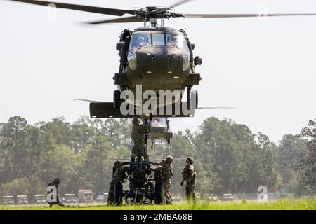 U.S. Army Soldiers with the Hunter Army Airfield-based 4th Battalion, 3rd Combat Aviation Brigade and the Brunswick-based Bravo Battery, 1st Battalion, 118th Field Artillery Regiment conduct sling-load operations during the Exportable Combat Training Capabilities exercise at Fort Stewart, Georgia, June 14, 2022. XCTC is the U.S. Army National Guard’s program of record that enables brigade combat teams to achieve the trained Platoon readiness necessary to deploy, fight, and win battles throughout the world. The XCTC exercise will include approximately 4,400 brigade personnel from throughout Geo Stock Photo