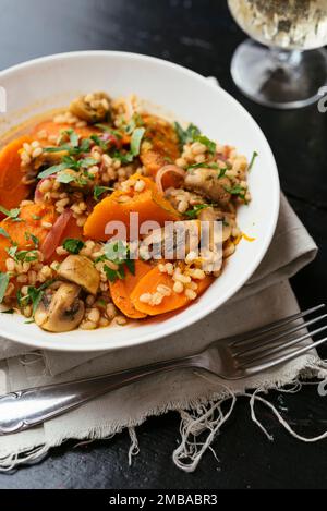 Winter squash with mushrooms, carrots barley cooked in white wine. Stock Photo