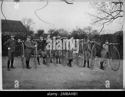 Possibly members of the Putney Cycling Club, England, c1890. Portrait of eight men in club kit posed for the camera with their penny farthing bicycles. The photograph may show members of the Putney Cycling Club. Penny farthing bicycles were in use from 1870, and were also known as the 'Ordinary' or 'High Wheeler'. The penny farthings shown in this image have different wheel sizes - the largest manufactured penny farthing had a wheel diameter of 60 inches. Stock Photo