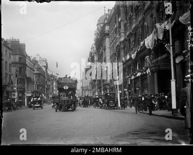 Hotel Cecil, The Strand, City of Westminster, Greater London Authority, 1911. A busy street scene outside the Hotel Cecil on Strand, showing cars, pedestrians and an open topped bus driving towards the foreground. The photograph is one of a batch taken by the photographer to show coronation decorations in London. There are flags and bunting decorating the front of the hotel for the coronation of King George V and Queen Mary on 22nd June 1911. Stock Photo